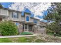 Inviting townhome featuring charming stone accents, covered entry, and landscaped front yard at 8943 Tappy Toorie Cir, Highlands Ranch, CO 80129