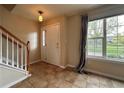 Bright foyer with tile flooring, staircase, and large window with backyard views at 438 N Parkside Dr # C, Longmont, CO 80501