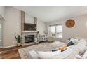 Cozy living room with a brick fireplace, modern furnishings, and a large window offering plenty of natural light at 9150 W 94Th Ave, Westminster, CO 80021