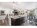 Modern kitchen featuring a granite countertop island, pendant lighting, and dark cabinetry at 6674 Fonder Villa Dr, Parker, CO 80134