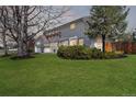 Suburban home featuring a sprawling lawn, mature trees, and a two-car garage at 5467 W Hinsdale Pl, Littleton, CO 80128