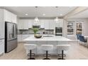 Modern kitchen with stainless steel appliances, a large island with seating, and white cabinetry at 8035 S Kewaunee St, Aurora, CO 80016