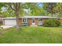 Charming single Gathering home featuring a brick exterior, attached garage, and landscaped yard at 8269 Zephyr St, Arvada, CO 80005