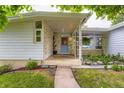 Cozy covered front porch with a stone accent wall and a blue front door, perfect for welcoming guests at 6748 S Gallup St, Littleton, CO 80120