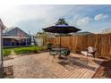 Brick patio featuring an umbrella table, chairs, and a wooden fence at 3052 S Cherokee St, Englewood, CO 80110