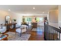 Bright living room showcasing hardwood floors, modern furniture, and an open floor plan to the kitchen and dining areas at 9410 Perry St, Westminster, CO 80031