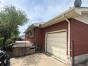 Brick home featuring a one-car garage and a nice cement slab on the side at 7127 Otis St, Arvada, CO 80003