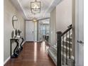 Stunning entryway with hardwood flooring, a decorative console table, and an adjacent staircase adding charm at 2669 Red Bird Trl, Castle Rock, CO 80108