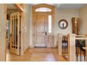 Grand foyer with wood floors, decorative tile, and a custom wood door at 1007 Nob Hill Rd, Evergreen, CO 80439
