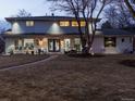 Charming home exterior with a manicured lawn and inviting entrance with a blue double door and warm lighting at 6111 W Fremont Dr, Littleton, CO 80128
