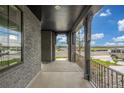 Inviting front porch featuring brick columns, a black ceiling, and a wrought iron railing at 1846 Chestnut Ave, Erie, CO 80516