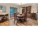 Elegant dining room with hardwood floors, wooden table set, built-in shelving, and natural light at 3265 W 11Th Avenue Ct, Broomfield, CO 80020