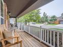 Inviting front porch with wooden bench seating, white railing, and view of the neighborhood street at 3265 W 11Th Avenue Ct, Broomfield, CO 80020
