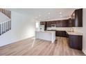 Modern kitchen with island, dark cabinetry, and light flooring at 544 Twilight St, Erie, CO 80516