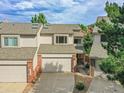 View of townhome front exterior with brick accents and a two-car garage at 12658 W 1St Pl # 78, Denver, CO 80228