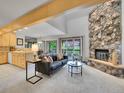 Bright living room with vaulted ceilings, a stone fireplace, and access to the deck at 12658 W 1St Pl # 78, Denver, CO 80228