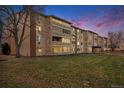 Multi-Gathering exterior with mid-century modern design and well-maintained lawn against a colorful sunset sky at 9315 E Center Ave # 3D, Denver, CO 80247