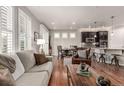 Open-concept living space with hardwood floors, great natural light, and a view of the kitchen at 7991 Heritage Dr, Thornton, CO 80602