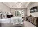 Luxurious main bedroom features a tray ceiling, bay window, and elegant chandelier at 7991 Heritage Dr, Thornton, CO 80602
