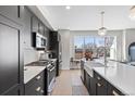 Modern kitchen boasts stainless steel appliances, a farmhouse sink, and a large window at 8028 W 52Nd Ln # B, Arvada, CO 80002