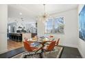 Well-lit dining area with modern decor, a glass table, and a view into the stylish, open kitchen at 8369 W Fairview Ave, Littleton, CO 80128