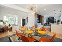 Bright dining room with a glass table, modern chairs, and open flow to the living area and kitchen at 8369 W Fairview Ave, Littleton, CO 80128
