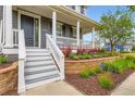 Inviting front porch featuring elegant columns and attractive flowerbeds and ADT security at 3597 Xanthia St, Denver, CO 80238