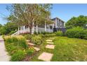 View of home and backyard landscape with stepping stones and flowering plants at 3597 Xanthia St, Denver, CO 80238