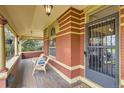 Inviting front porch with wood flooring, comfortable seating, and classic brick detailing at 835 Niagara St, Denver, CO 80220