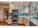 Renovated kitchen with stainless steel appliances, granite countertops, and custom tile backsplash at 835 Niagara St, Denver, CO 80220