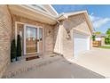 Welcoming front porch with a light-toned brick exterior, showcasing a stylish glass-paneled front door at 1809 Little Bear Ct, Longmont, CO 80504