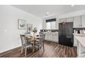Cozy dining area with a round table, seating for four, and view of modern kitchen finishes at 18129 E 99 Pl, Commerce City, CO 80022