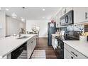 Bright kitchen with stainless steel appliances, island, and a view of the dining area at 18129 E 99 Pl, Commerce City, CO 80022
