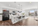 Modern kitchen with stainless steel appliances, a large center island, and hardwood floors at 18129 E 99 Pl, Commerce City, CO 80022