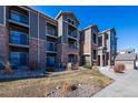 Attractive condo building featuring brick accents, neutral siding, and private balconies under a clear blue sky at 3100 Blue Sky Cir # 205, Erie, CO 80516