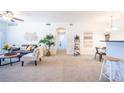 Open-concept living area leads to the dining and kitchen areas with neutral carpeting at 3100 Blue Sky Cir # 205, Erie, CO 80516
