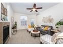 Comfortable living room with neutral walls, soft carpeting, a ceiling fan, and a modern electric fireplace at 3100 Blue Sky Cir # 205, Erie, CO 80516