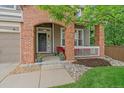 Welcoming front porch with brick columns and a seating area, perfect for enjoying the outdoors at 3860 Mallard Dr, Highlands Ranch, CO 80126