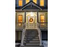 Charming front door with decorative wreath, sidelights, and steps leading to the porch at 6857 Timbers Drive, Evergreen, CO 80439