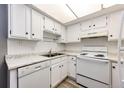 White kitchen with updated appliances and wood-look floors at 13890 E Marina Dr # 107, Aurora, CO 80014