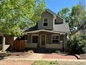 Charming home with a brick pathway leading to a cozy front porch, surrounded by mature trees at 3440 W 33Rd Ave, Denver, CO 80211