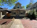 Inviting home with a covered porch, a brick walkway, and lush landscaping enhancing curb appeal at 3440 W 33Rd Ave, Denver, CO 80211