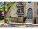 Front elevation of an apartment building with stair access, blue door, and tree lined frontage at 12108 Melody Dr # 103, Denver, CO 80234