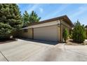 The garage of this home has space for two cars with a large concrete driveway and a brick and siding exterior at 5030 Titan Ct, Denver, CO 80239