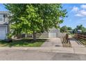 View of the front of the two-story home, showcasing the driveway, attached garage, and well-maintained lawn at 11898 W Tufts Pl, Morrison, CO 80465