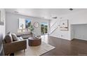 Bright living room with hardwood floors, a modern sofa, and large windows offering natural light at 11898 W Tufts Pl, Morrison, CO 80465
