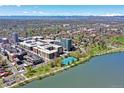 Panoramic aerial view showcases the community's proximity to a serene lake, tennis courts, and mountain views at 4200 W 17Th Ave # 235, Denver, CO 80204