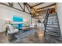 Spacious living room with concrete floors, exposed beams, open staircase, and modern furnishings at 1111 Osage St # 29, Denver, CO 80204