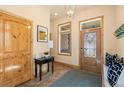 Welcoming entryway with decorative door, tiled floor, coat closet, and stylish light fixture at 2673 S Cook St, Denver, CO 80210