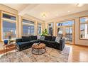 Sunlit living room with large windows, hardwood floors, and a comfortable sectional sofa at 2673 S Cook St, Denver, CO 80210